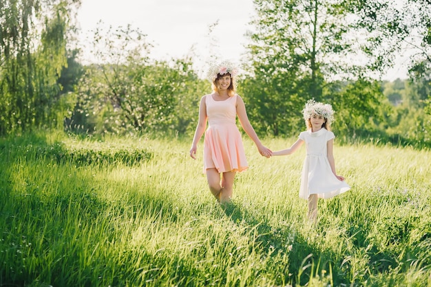 Madre e hija caminando en el campo en el verano Día soleado al atardecer