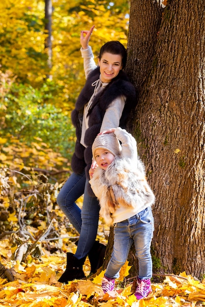 Madre e hija caminando en el parque otoño