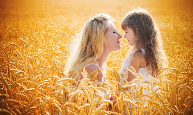 Madre e hija en un campo de trigo. enfoque selectivo