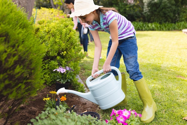 Madre e hija caucásicas pasando tiempo juntas en el jardín y regando plantas. Pasar tiempo en familia al aire libre, jardín, jardinería, concepto.