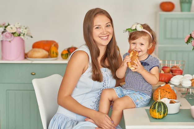 Madre e hija en la cocina con decoraciones de Acción de Gracias