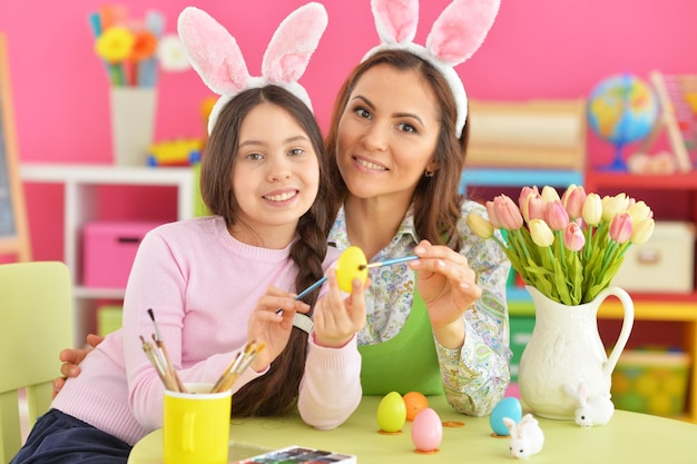 Madre e hija coloreando huevos a Pascua