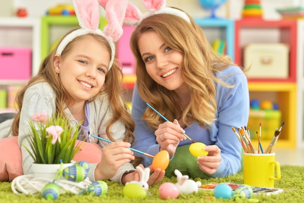 Madre e hija coloreando huevos