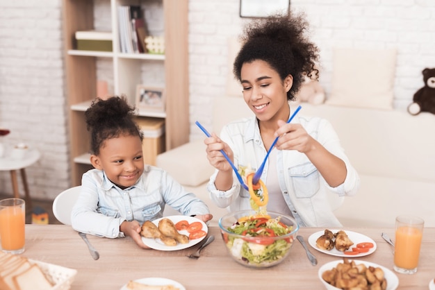 Madre e hija comen juntas en la cocina.