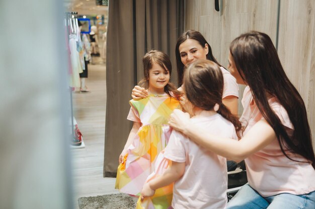 Madre e hija compran ropa madre y niña probándose ropa en la tienda
