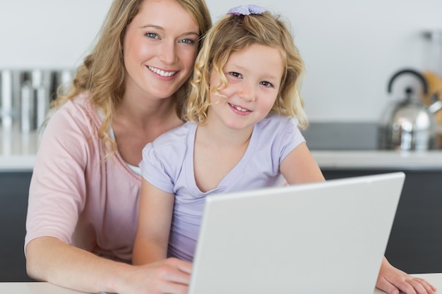 Foto madre e hija, con, computadora portátil, en, cocina