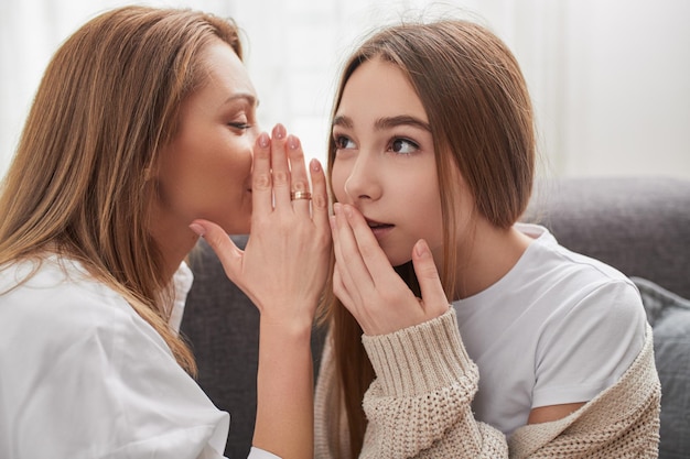 Madre e hija cotilleando en el sofá