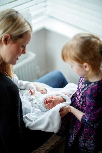 Madre e hija cuidando a un bebé recién nacido