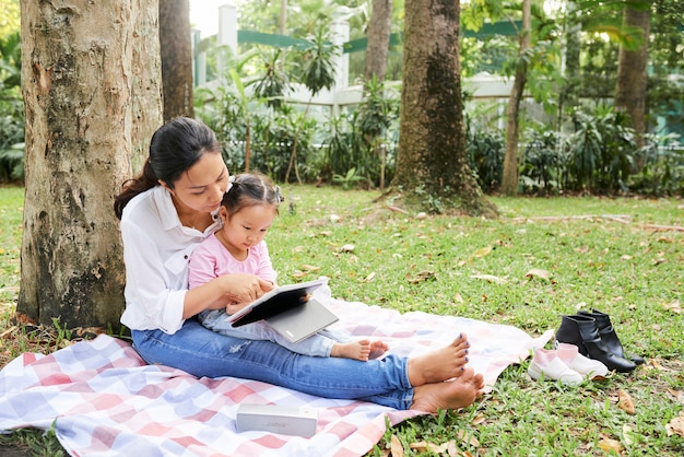 Madre e hija descansando bajo un árbol