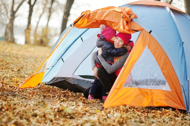 Madre e hija descansando en un campamento.