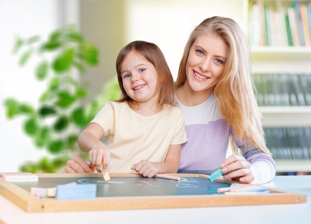 Madre e hija dibujando juntas en la pizarra