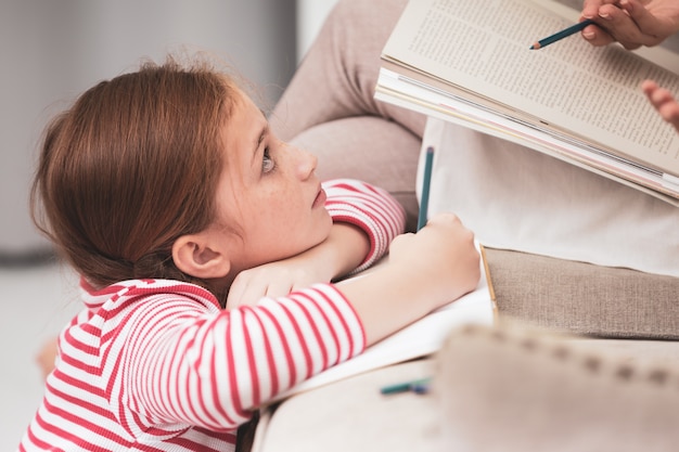 Madre e hija dibujando con lápices de colores en el libro