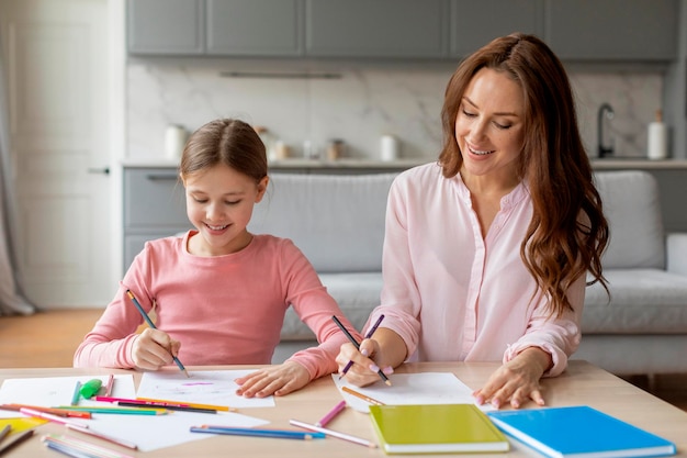 Madre e hija disfrutando de dibujar juntos el interior de la casa