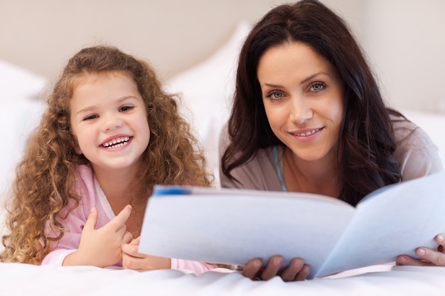 Madre e hija disfrutando leyendo juntos