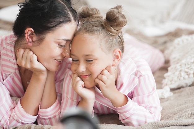 Madre e hija se divierten en casa. Chicas en el interior.