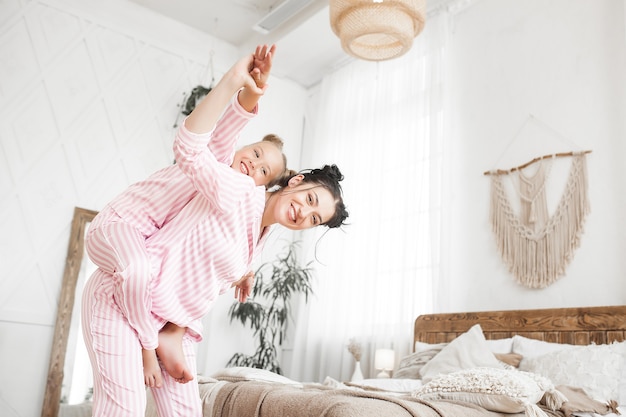 Madre e hija se divierten en casa. Chicas en el interior.