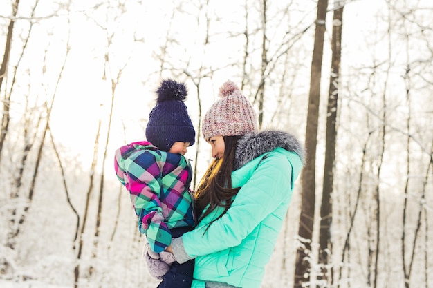 Madre e hija se divierten en el parque de invierno.