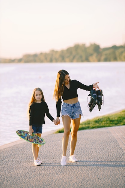 Madre e hija se divierten patinando en el parque