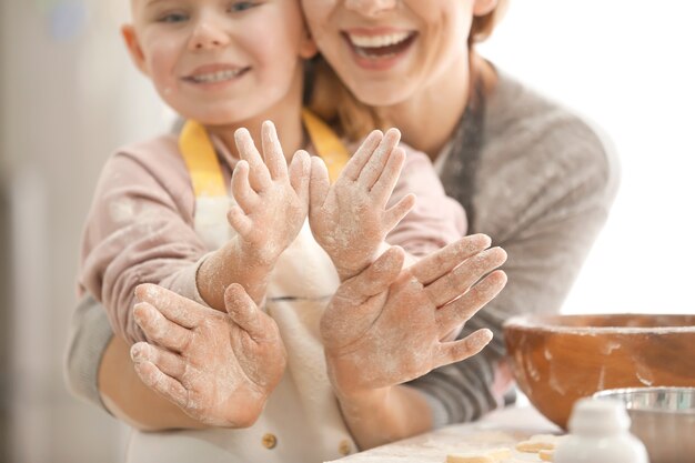 Foto madre e hija divirtiéndose con harina en la cocina