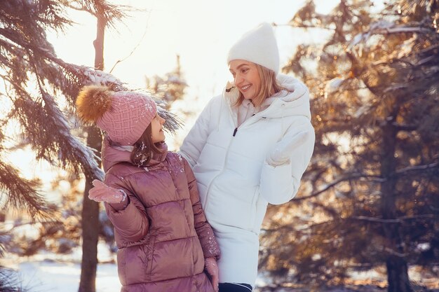 Madre e hija divirtiéndose en el parque de invierno.