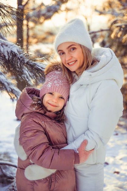 Madre e hija divirtiéndose en el parque de invierno.