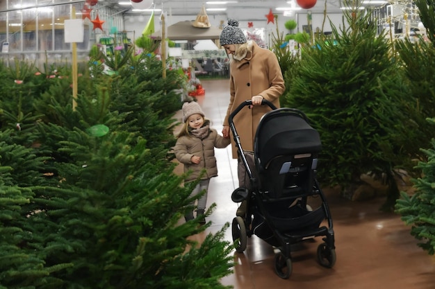 Madre e hija eligen un árbol de Navidad en una tienda