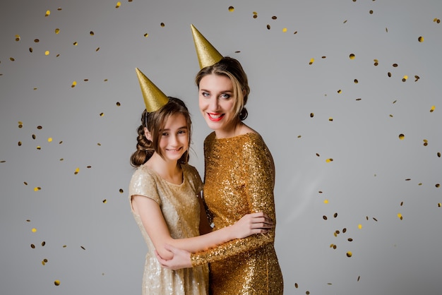 Madre e hija encantadoras y elegantes en hermosos vestidos de moda