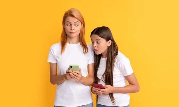 Madre e hija escribiendo y enviando mensajes de texto y mensajes instantáneos blogueros de mamá y niños