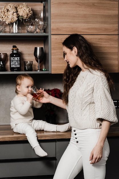 Madre e hija están bebiendo una taza de té en la cocina Maternity Mon y su hijo pasan tiempo juntos en casa