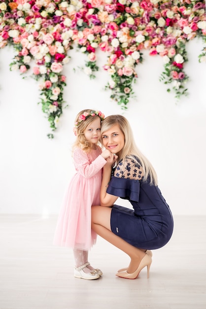 Foto madre e hija en un estudio con flores.