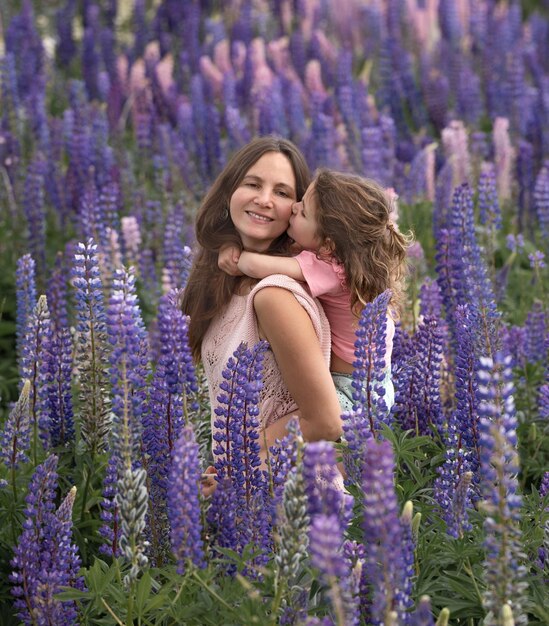 Madre e hija felices en campo de altramuces azules