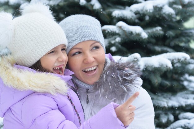 Madre e hija felices, posando al aire libre en invierno