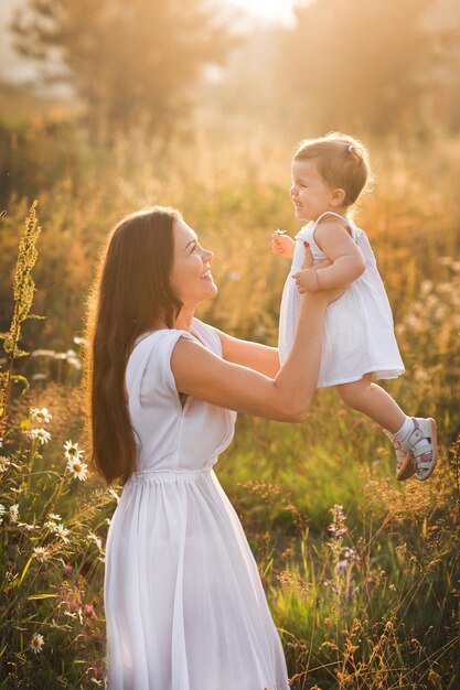 Madre e hija en fotos soleadas juegan entre dientes de león 3018