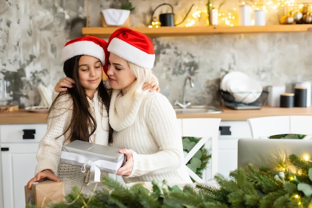 Madre e hija frente al árbol de Navidad.