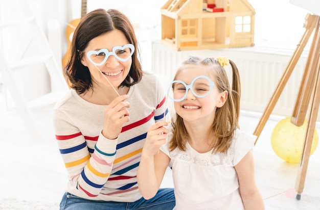 Madre e hija con gafas de palo