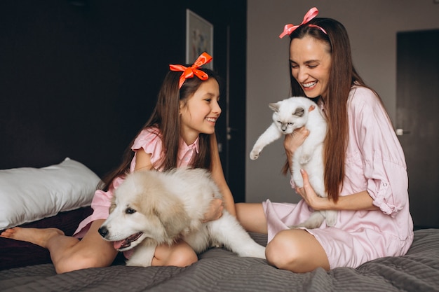 Madre e hija con gatito y perro