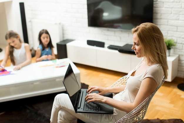 Madre e hija en la habitación en la computadora portátil en casa