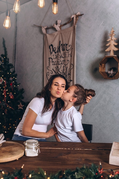 Madre e hija en una habitación con decoraciones navideñas