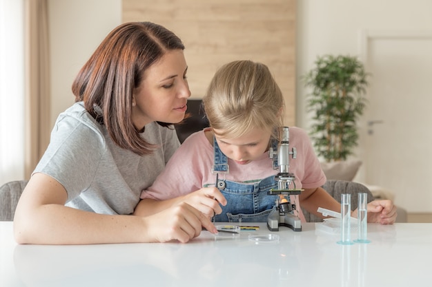 Madre e hija hacen experimentos químicos con microscopio en casa