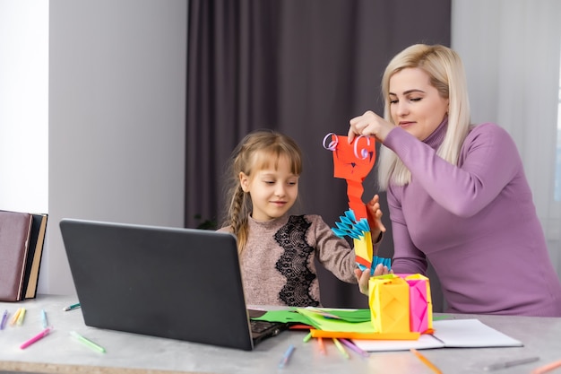 madre e hija hacen manualidades en papel juntas