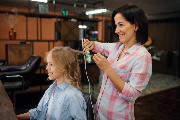 Madre e hija hacen sus peinados en peluquería