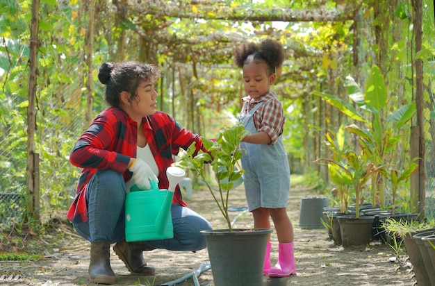 Madre e hija haciendo actividades al aire libre en el jardín familia diversa feliz fin de semana de maternidad junto con el niño Concepto del día de la madre