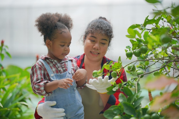 Madre e hija haciendo actividades al aire libre en el jardín familia diversa feliz fin de semana de maternidad junto con el niño Concepto del día de la madre