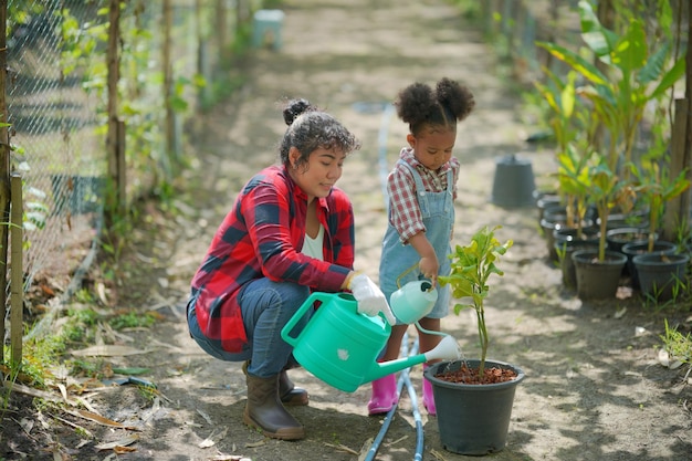 Madre e hija haciendo actividades al aire libre en el jardín familia diversa feliz fin de semana de maternidad junto con el niño Concepto del día de la madre