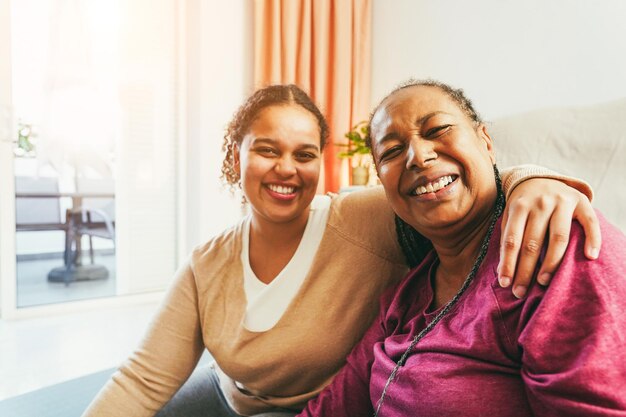 Madre e hija haciendo ejercicios de fitness juntos en casa Concepto familiar y deportivo durante el invierno Centrarse en la cara de la mujer mayor