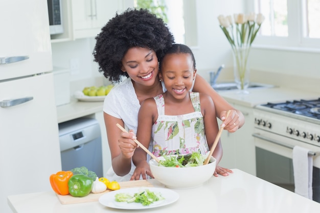 Madre e hija haciendo una ensalada juntos