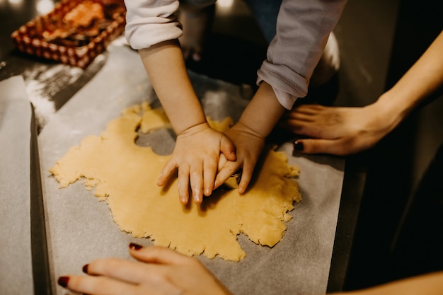 Madre e hija haciendo galletas en forma de corazón con cortadores de galletas de metal