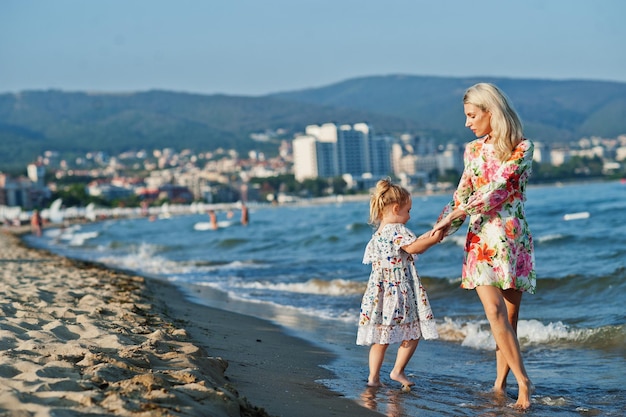 Madre e hija hermosa divirtiéndose en la playa Retrato de mujer feliz con linda niña de vacaciones