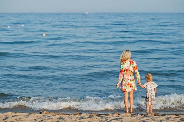 Madre e hija hermosa divirtiéndose en la playa Retrato de mujer feliz con linda niña de vacaciones