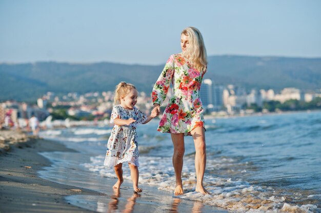 Madre e hija hermosa divirtiéndose en la playa Retrato de mujer feliz con linda niña de vacaciones